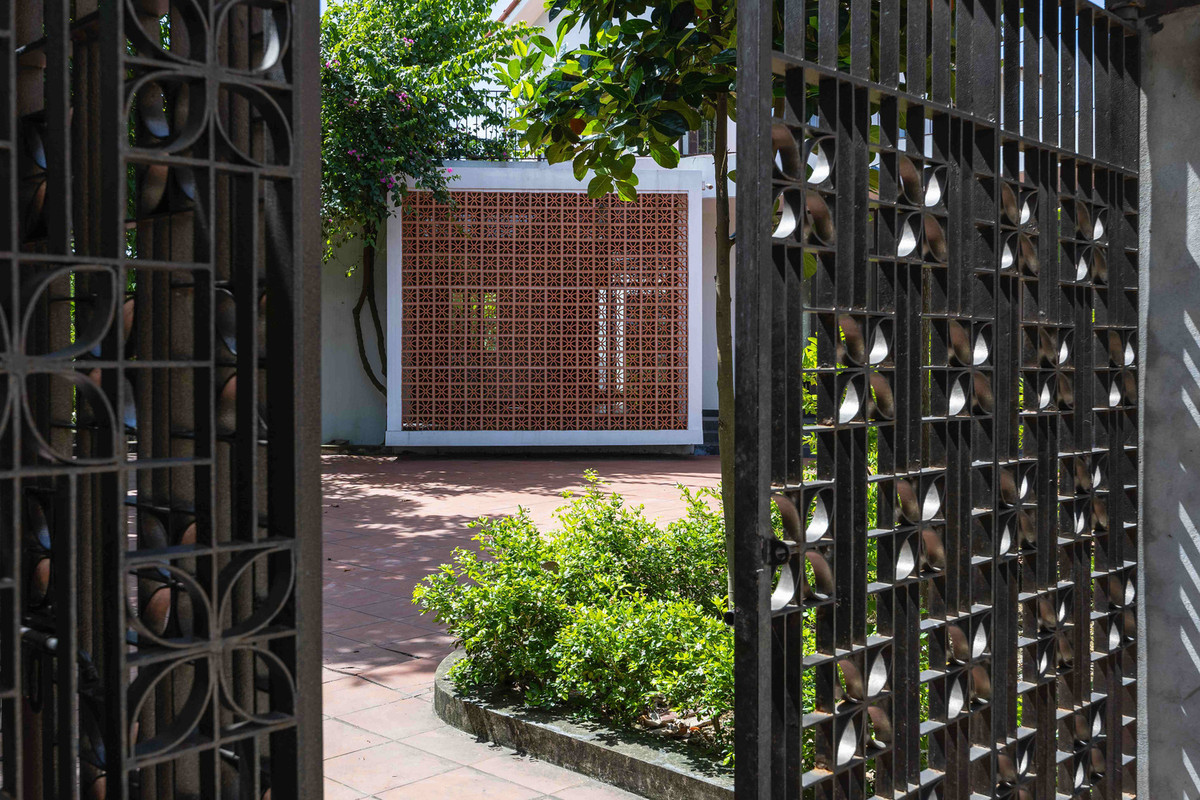 Sân vườn sử dụng gạch men đỏ, trần nhà hoàn thiện ở tầng hai được làm bằng tre, tạo nên bầu không khí hiện đại nhưng thân thiện và ấm cúng. Ảnh: Triệu Chiến