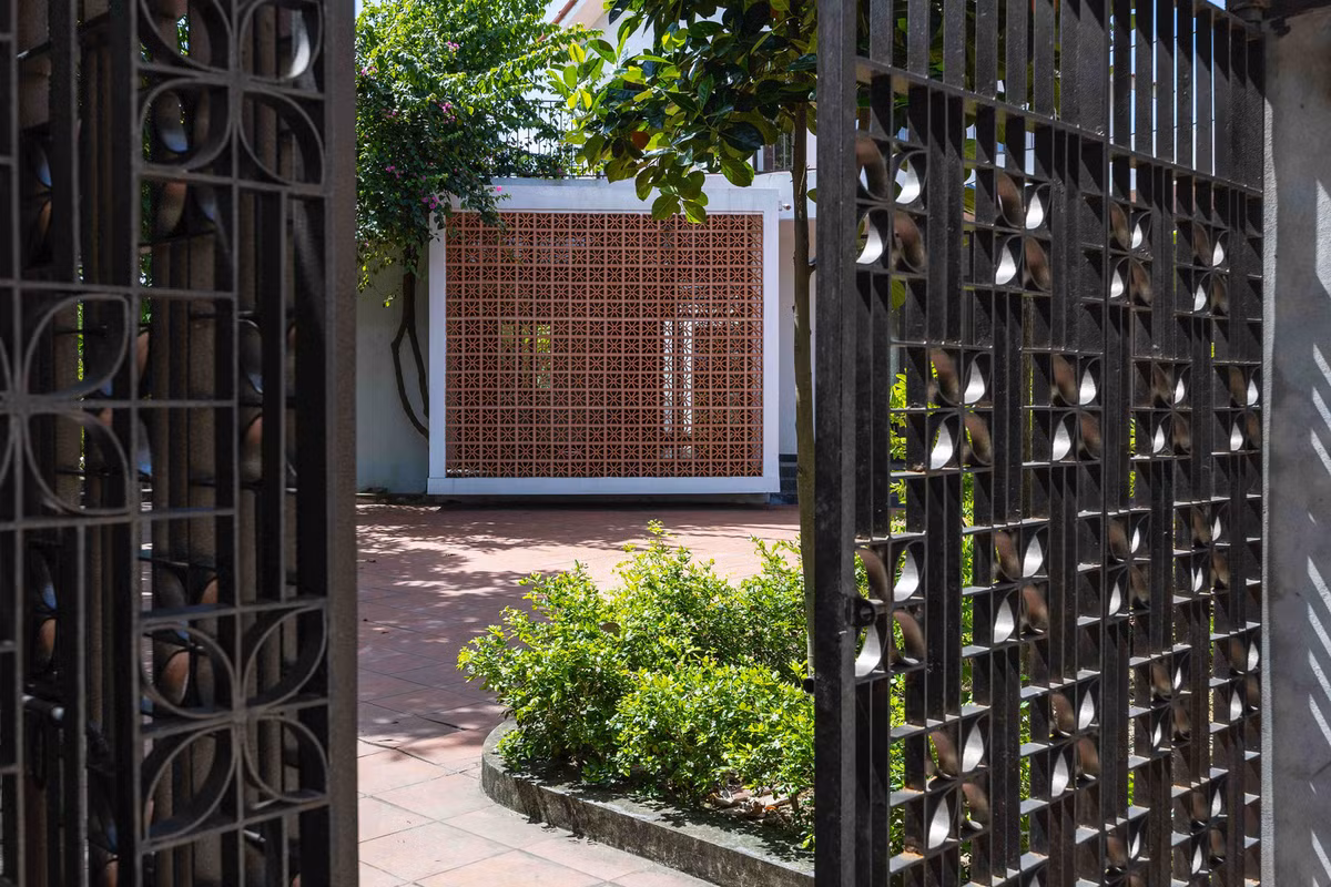 Sân vườn sử dụng gạch men đỏ, trần nhà hoàn thiện ở tầng hai được làm bằng tre, tạo nên bầu không khí hiện đại nhưng thân thiện và ấm cúng. Ảnh: Triệu Chiến