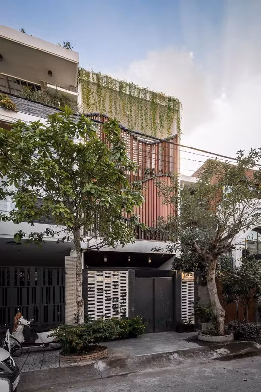 Tọa lạc tại TP Cần Thơ, ngôi nhà gây ấn tượng với thiết kế khác biệt. Mặt tiền được bố trí hệ thống khung nhôm vân gỗ lượn sóng và có thể thay đổi hình dạng. Ảnh: Architizer