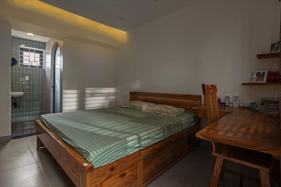 Từ hành lang, có thể nhìn thấy phòng ngủ master, được bố trí đơn giản, đi kèm với một phòng thay đồ đáp ứng nhu cầu sử dụng của gia chủ. Ảnh: GreenConcept