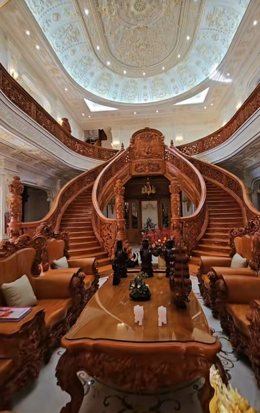 Bước vào bên trong, phòng khách gây choáng ngợp bởi cầu thang gỗ thiết kế uốn vòng cung. Ảnh: @tan_nguyenminh