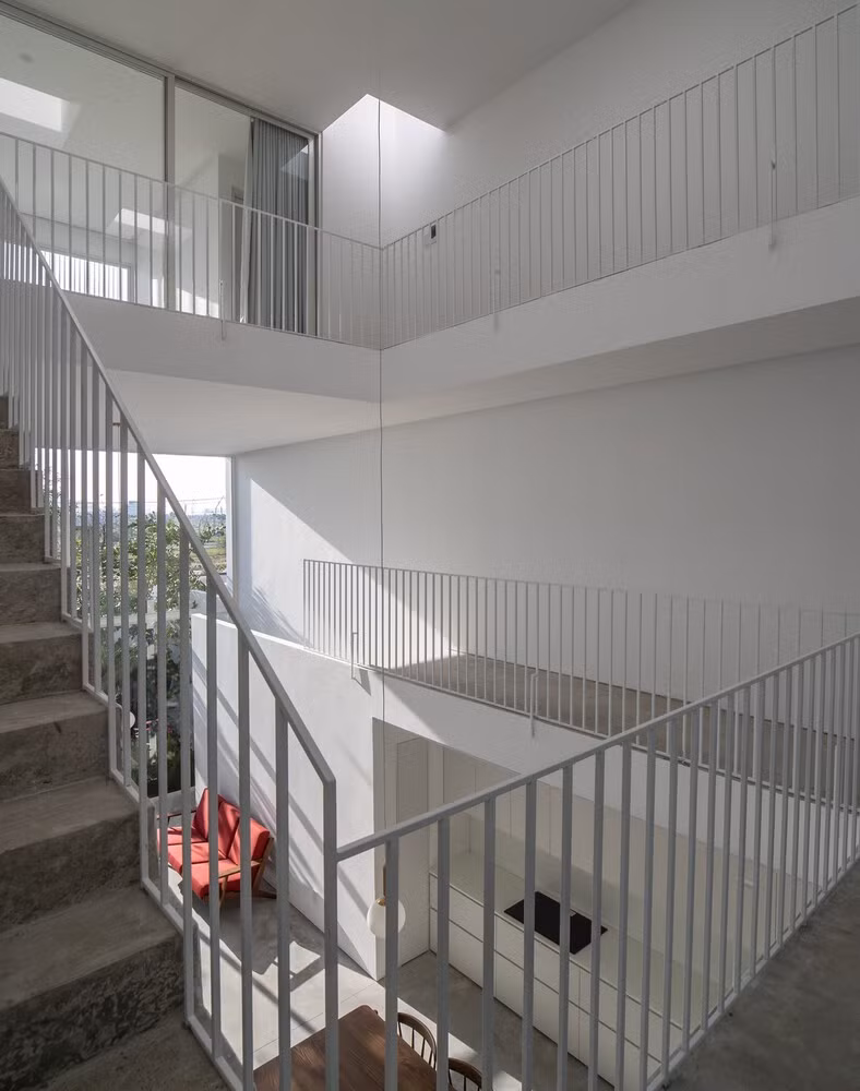 Lối đi xoắn ốc quanh giếng trời tạo cảm giác về một lõi trung tâm, kết nối phần còn lại của không gian và thay đổi góc nhìn một cách năng động khi có người ngang qua. Ảnh: Hoàng Lê