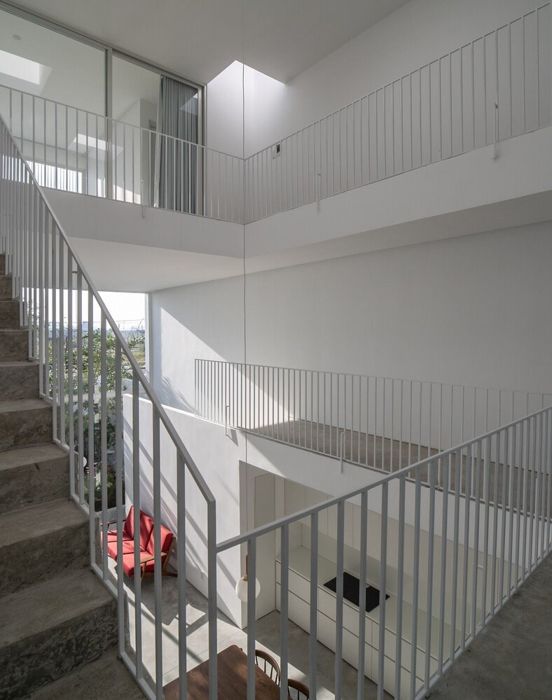 Lối đi xoắn ốc quanh giếng trời tạo cảm giác về một lõi trung tâm, kết nối phần còn lại của không gian và thay đổi góc nhìn một cách năng động khi có người ngang qua. Ảnh: Hoàng Lê