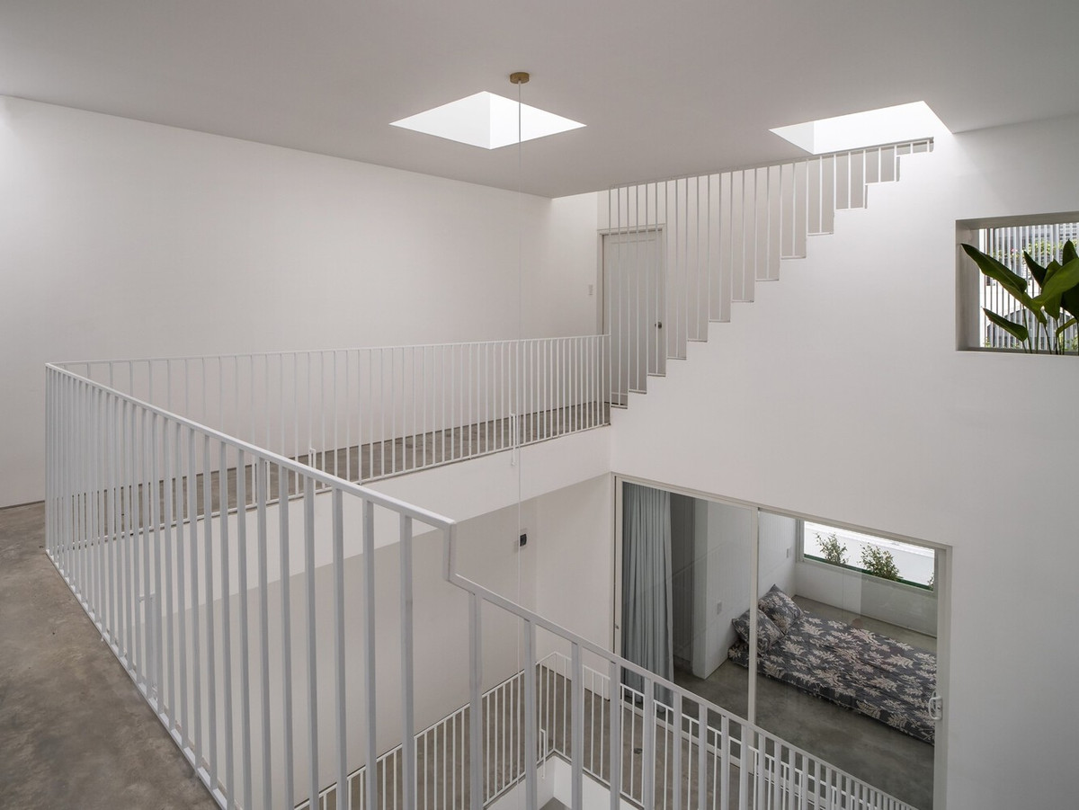 Để ngôi nhà 3 tầng sở hữu không gian liền mạch và ấn tượng như sàn diễn thời trang, kiến trúc sư thiết kế lối giao thông gồm cầu thang, hành lang kết hợp với khoảng thông tầng tạo ra vô số điểm quan sát. Ảnh: Hoàng Lê