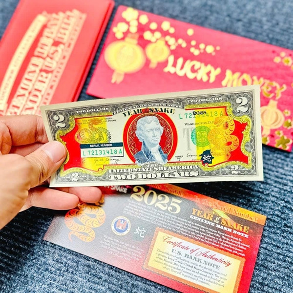 Mỗi tờ 2 USD mạ vàng linh vật rắn có mức giao dịch từ 120.000-150.000 đồng. Ảnh: Tienquocte