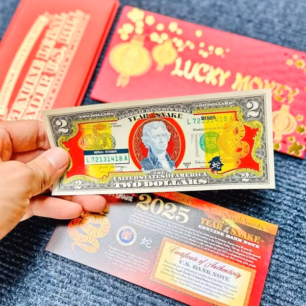 Mỗi tờ 2 USD mạ vàng linh vật rắn có mức giao dịch từ 120.000-150.000 đồng. Ảnh: Tienquocte