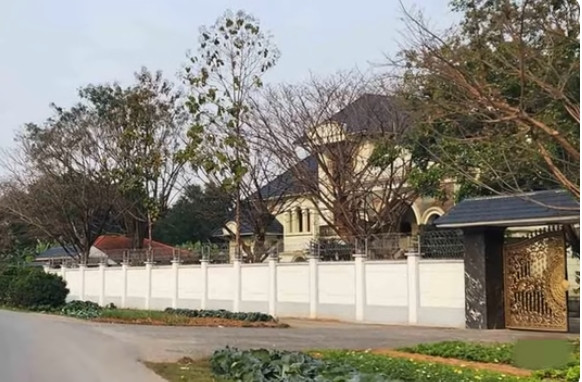 Căn biệt phủ rộng hàng nghìn m2, kéo dài cả trăm mét theo mặt đường quốc lộ 2C cũ, bao quanh bởi tường rào sơn màu trắng. Ảnh: SKĐS