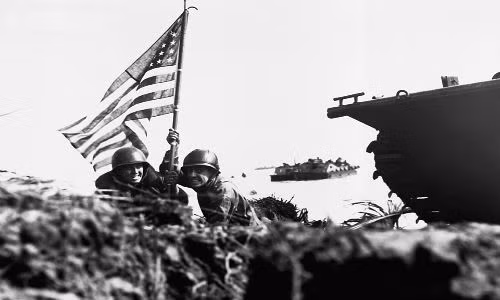 Hình ảnh lịch sử hai lính Mỹ cắm cờ lên bãi biển Guam, 8 phút sau khi lực lượng lính thủy đánh bộ và lục quân Mỹ đặt chân lên đảo này vào ngày 20/7/1944. Trong trận chiến khốc liệt giành lại đảo Guam, Mỹ đã mất 1.700 binh sĩ trong khi phía Nhật tổn thất 18.000 người.