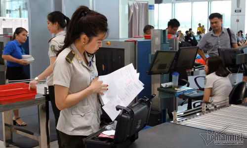 Đáng chú ý, có những khẩu súng nhựa đồ chơi trẻ em cũng bị lực lượng an ninh buộc phải giữ lại, đồng thời hành khách phải ký vào bản ghi nhớ. Trong ảnh là nhân viên an ninh Nguyễn Thị Bích Ngọc kiểm tra giấy tờ liên quan đến một chiếc máy lạ mắt.