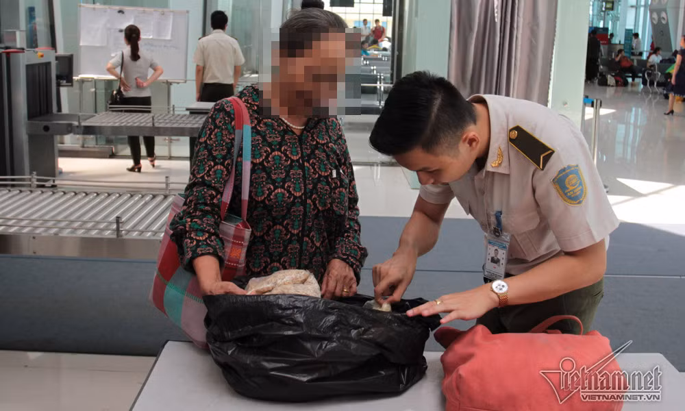 Kiểm tra bọc túi đen phát hiện nhiều tép tươi và một số sản vật ở quê mang vào miền Nam được gói sơ sài. Nhân viên an ninh yêu cầu ra ngoài bọc lại thật kỹ để tránh bốc mùi trên máy bay.