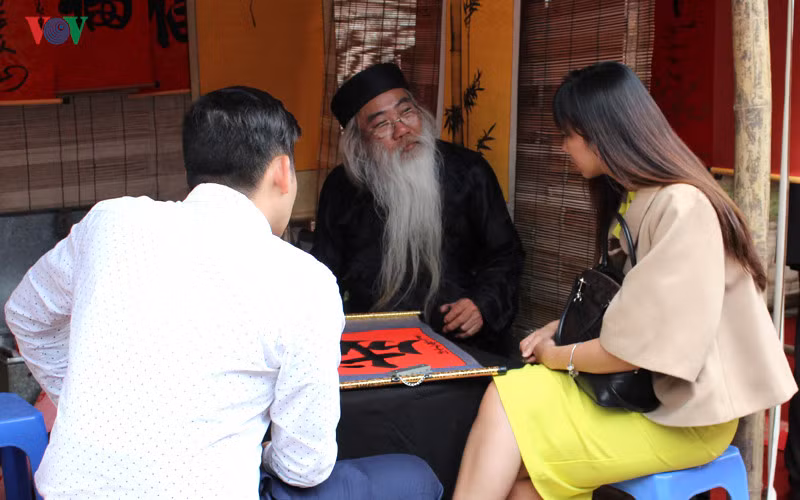 Ông đồ hàn huyên cùng người xin chữ.