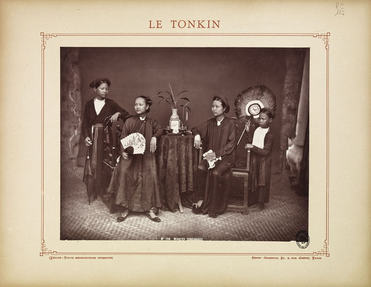 Hai phụ nữ người Việt thuộc dòng dõi quyền quý ngồi ghế và hai nữ hầu đứng hai bên.