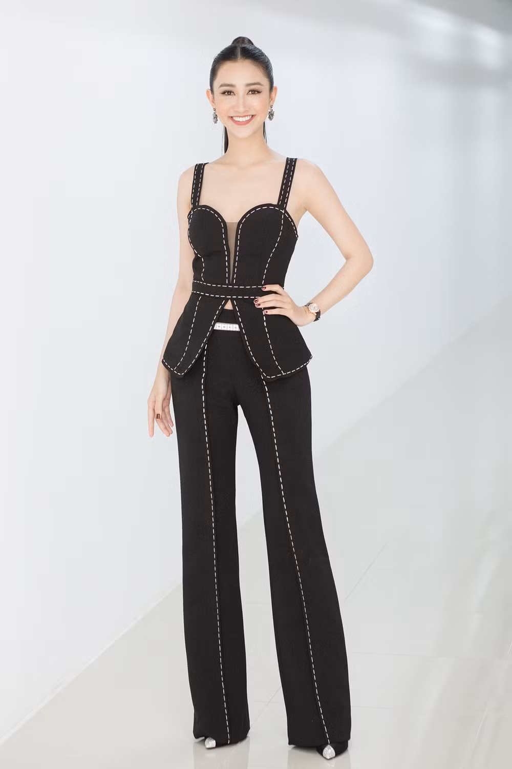 Cô diện bộ trang phục đen điểm xuyến sọc trắng với phần áo được thiết kế cắt cúp táo bạo cùng chiếc quần dài giúp khoe đôi chân miên man.