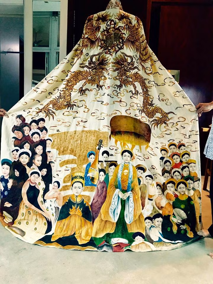 Họa tiết nổi bật trong bộ “Hoàng bào” này chính là hình ảnh “Long phụng” bay lượn trên những tầng mây. Phần dưới là hình ảnh tầng tầng, lớp lớp con người sống sung túc, tượng trưng cho “con rồng cháu tiên”, thể hiện sự hưng thịnh, đoàn kết các dân tộc anh em.