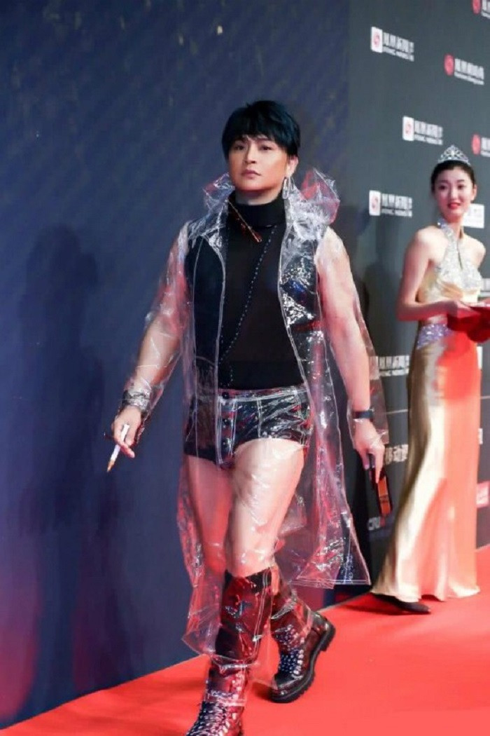 Chàng "Nhĩ Thái" tiếp tục đốt mắt khán giả với trang phục không giống ai: Áo xuyên thấu màu đen kết hợp cùng quần lót ngắn cũn cỡn, áo mưa trong suốt dài tới gót và giày chiến binh. Phụ kiện kết hợp của nam diễn viên còn có khuyên tai là kim băng bản to.