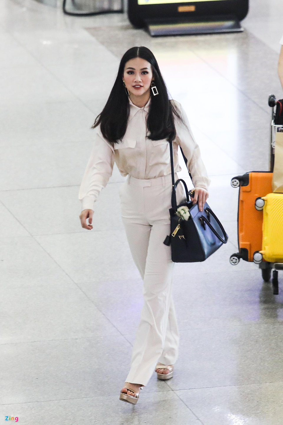 Hơn 14h ngày 11/11, Phương Khánh xuất hiện xinh đẹp rạng rỡ tại khu vực lấy hành lý sau chuyến bay. Tân hoa hậu Trái đất 2018 diện cây trắng thanh lịch, tóc để ngôi giữa đơn giản và trang điểm khá kỹ.
