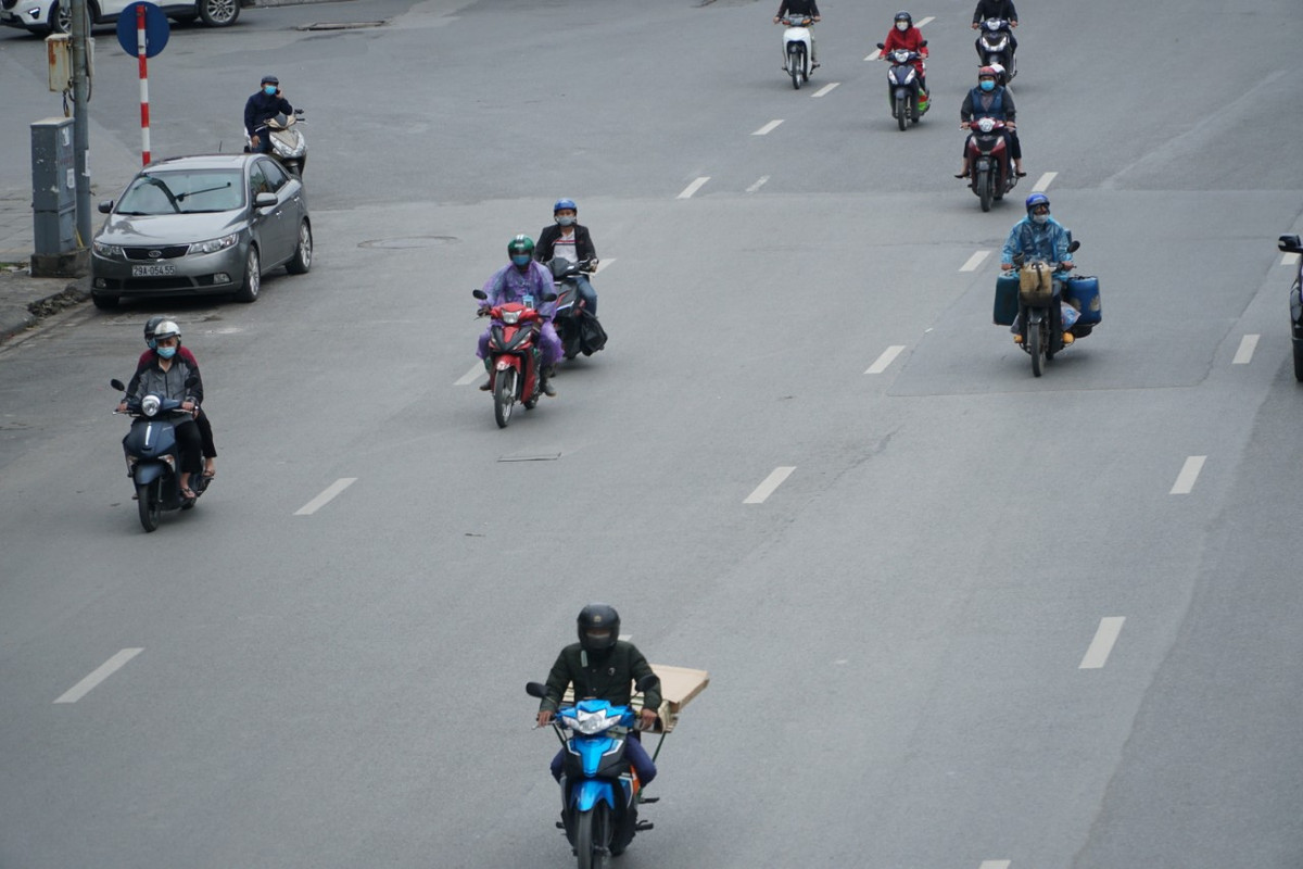 Do thời tiết Hà Nội hôm nay một số khu vực có mưa nên người dân phải mặc thêm áo mưa khi đi làm.