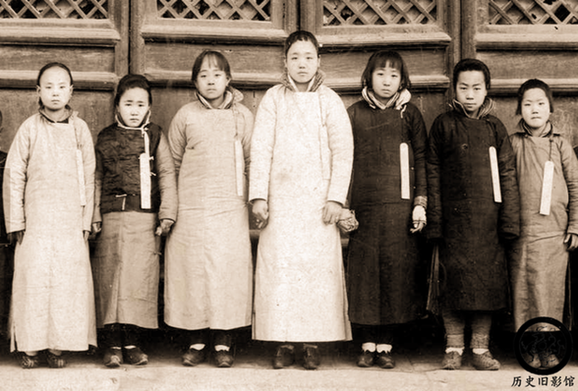 Những bé gái đeo một tấm thẻ gỗ trên người ghi tên tuổi, quê quán khi tham gia tuyển chọn cung nữ trong Tử Cấm Thành. Theo quy định của hoàng tộc nhà Thanh, những bé gái này đều dưới 13 tuổi. Bức ảnh chụp cho thấy, những đứa trẻ này có dung mạo bình thường.