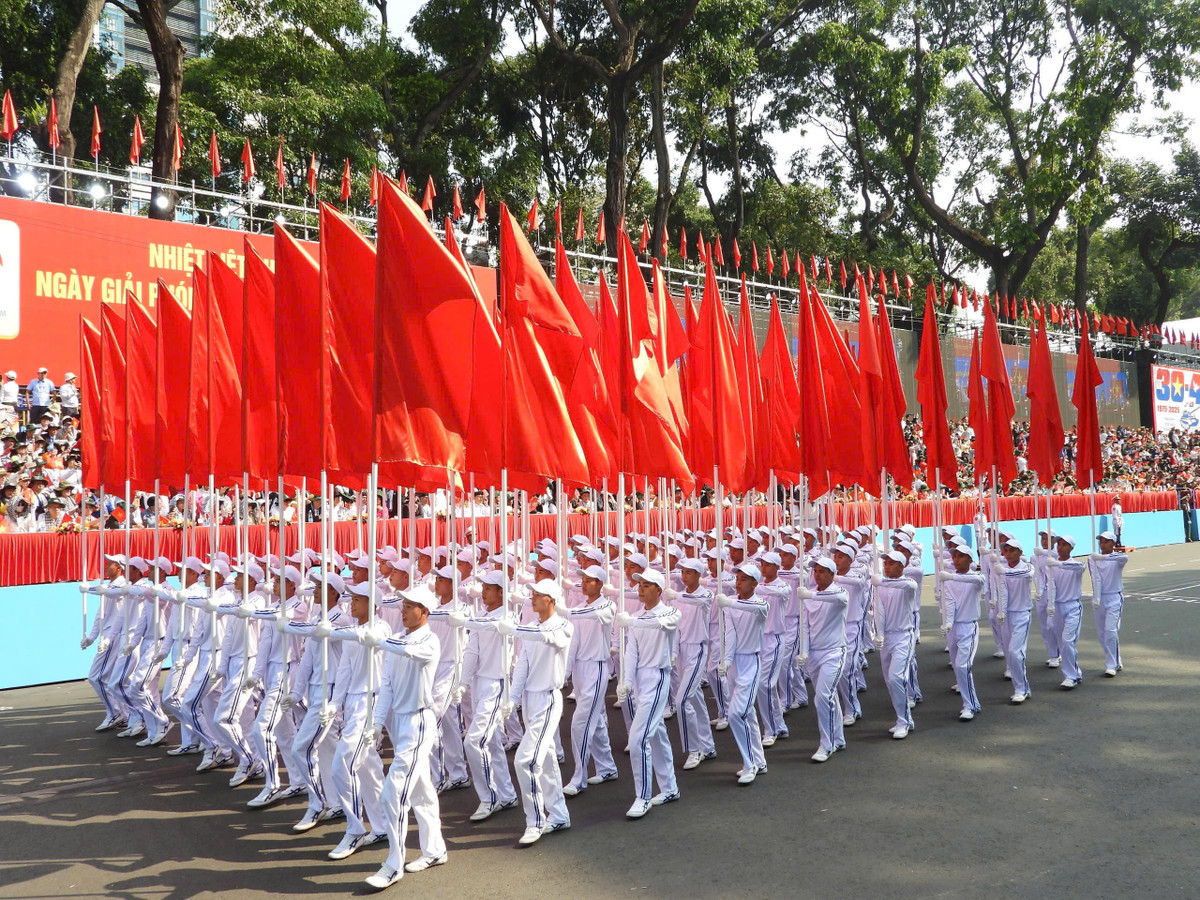 Khối Hồng kỳ: Những lá cờ tươi thắm, rực rỡ, thể hiện niềm kiêu hãnh, tự hào, tự tôn của dân tộc Việt Nam. Dưới lá cờ vinh quang, toàn Đảng, toàn dân, toàn quân ta đã đoàn kết chặt chẽ, anh dũng chiến đấu và giành thắng lợi to lớn trong các cuộc kháng chiến giải phóng dân tộc, bảo vệ Tổ quốc mà đỉnh cao là đại thắng mùa xuân năm 1975, thu non song về một mối.