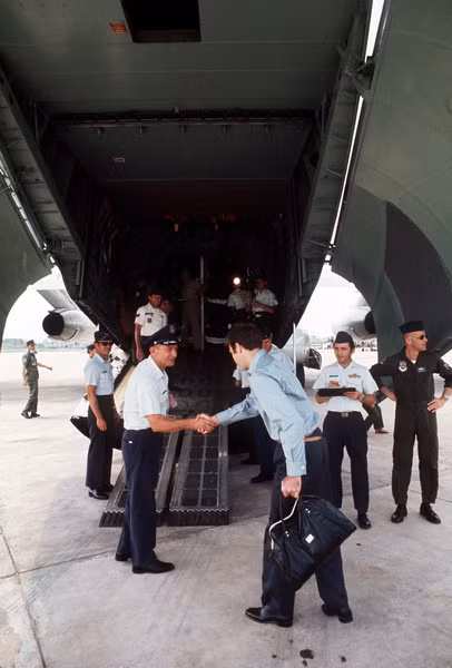 Tù binh đầu tiên bước lên khoang máy bay được chào đón.