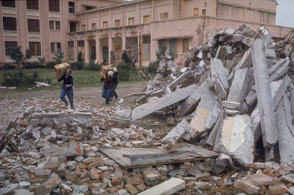 Dân quân khiêng các thùng gỗ ra khỏi nhà máy xe đạp bị ném bom gần Hà Nội.
