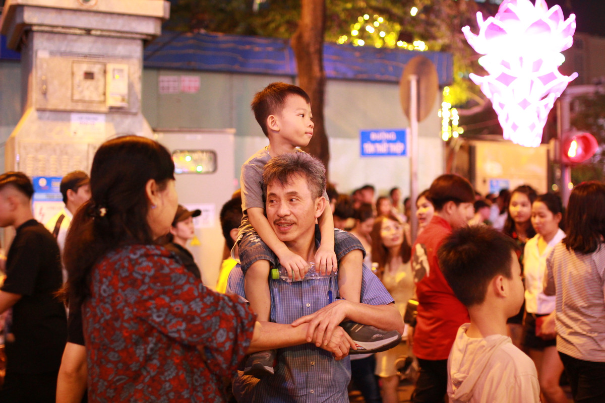  Phố đi bộ Nguyễn Huệ thuộc trung tâm Quận 1 là nơi rất đông người tập trung để chờ xem pháo hoa tầm cao trên nóc hầm Thủ Thiêm. Tất cả các ngả đường xung quanh khu vực này đều được chặn, không cho các phương tiện lưu thông. Một em bé được cha cho xuống phố chờ xem pháo hoa và cùng chờ đợi thời khác đếm ngược (countdown) và trình chiếu ánh sáng 3D lên tòa nhà UBND TP.HCM. 