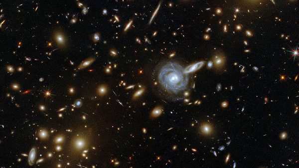 Theo các nhà khoa học đến từ Đại học Hawaii (Mỹ) và Đại học Heidelberg (Đức), hiện tượng này là do lực hấp dẫn khổng lồ của một cụm thiên hà chưa được phân loại, đã làm cong không thời gian.