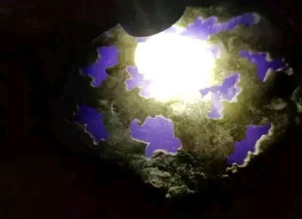 Viên đá có màu tím tuyệt đẹp và hình dáng cũng rất kỳ lạ. Nhìn trên bề mặt, viên đá như thể thủng lỗ chỗ. Qua những chiếc lỗ trên bề mặt, ông lão mới có thể thấy màu tím từ lớp đá bên dưới. Lớp màu tím bên trong được bọc bởi một lớp vỏ màu xám.