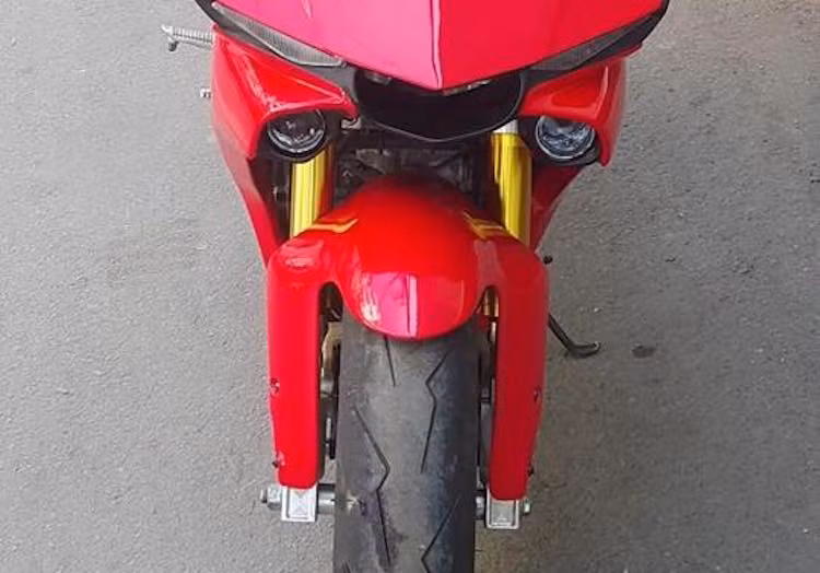 Trong khi đó ở bên dưới, "dàn chân" trước của chiếc xe cũng đã được chủ nhân quan tâm khi độ cặp phuộc USD cắt ngắn từ xe phân khối lớn kèm chảng ba CNC vào Exciter. Bánh trước có hệ thống phanh đĩa được nâng cấp lên đĩa kép, kèm cặp heo Brembo 2 pis đối xứng và lốp Pirelli Supercorsa có độ bám đường lớn.