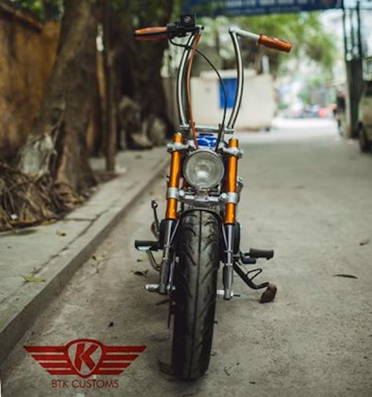 Bắt đầu từ phía trước, dàn đầu nguyên bản của Monkey đã được thay thế toàn bộ với đèn pha cùng chảng ba mới, đi kèm với cặp phuộc USD khỏe khoắn hơn. Tay lái của chiếc xe đã được xưởng độ "thửa riêng" với chiều cao cực lớn, tạo thành dạng ghi-đông "Ape hanger" giống nhiều mẫu xe môtô độ chopper.