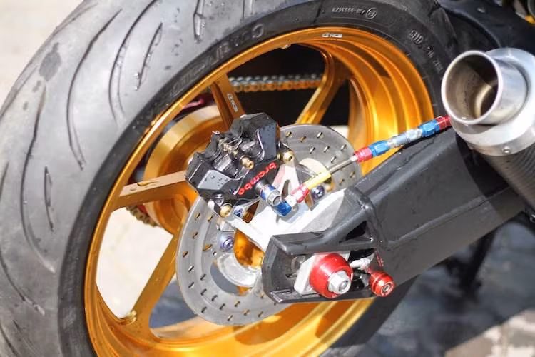 Với mâm sau bản lớn, toàn bộ gắp sau của Exciter 150 nguyên bản đã bị bỏ đi để nhường chỗ cho gắp BMW S1000RR. Cả 2 lốp xe sử dụng lốp Continental ContiMotion, trong khi hệ thống phanh sau đã được nâng cấp lên heo Brembo Billet.