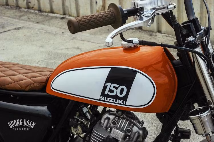 Phần bình xăng là điểm nổi bật trên bản độ EN150A này khi Duong Doan Design đã gò cho chiếc xe bình hoàn toàn mới với thiết kế cổ điển và chiều rộng nhỏ. Điểm đặc biệt của bình xăng là được sơn màu đỏ với các họa tiết trang trí trắng/đen theo phong cách chiếc scrambler Yamaha SCR950.