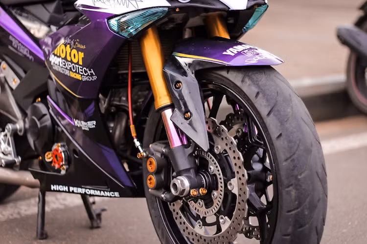 "Dàn chân" trước là một trong những điểm nhấn của chiếc xe khi sở hữu cặp phuộc USD đường kính lớn được cắt từ một mẫu xe phân khối lớn khác, đi kèm với đĩa và mâm của Kawasaki ZX-12R. Cặp heo phanh từ Yamaha R6 và dây dầu Morin giúp hoàn thành hệ thống phanh trước của xe.