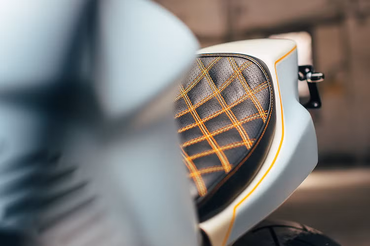 Để tạo ấn tượng về sự tương phản, Wenley đã nhờ tới một người thợ sơn ở gần xưởng là Jack Johnson. Phần thân xe có màu xanh nhạt kết hợp với trắng, được ngăn với nhau bởi những đường viền cam, trong khi bộ khung được sơn lại màu đen. Nằm trên phần đuôi dạng flat tracker là chiếc yên mỏng với bề mặt chần chỉ con thoi kiểu cổ điển, với chỉ màu cam lấy cảm hứng từ siêu xe Lamborghini.