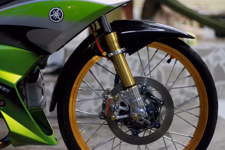 Không chỉ có dàn áo của X1, chiếc Jupiter này còn sở hữu hàng loạt những món đồ chơi cao cấp. "Dàn chân" của chiếc xe đã được nâng cấp bằng niềng căm trọng lượng nhẹ, trong khi hệ thống phanh trước gồm đĩa đặc và heo Brembo Billet 4 piston. Vỏ phuộc của xe cũng đã được thay thế với màu vàng đẹp mắt.