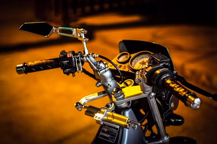 Bảng đồng hồ và tay lái nguyên bản của mẫu xe côn tay 2 kỳ Nova Dash RS được giữ nguyên. Tuy nhiên để chiếc xe an toàn hơn ở tốc độ cao, chủ xe đã lắp thêm cây trợ lực Ohlins dưới cổ. Nằm bên tay lái trái là chiếc kính chiếu hậu Rizoma 851, trong khi bên phải là cùm ga Domino.