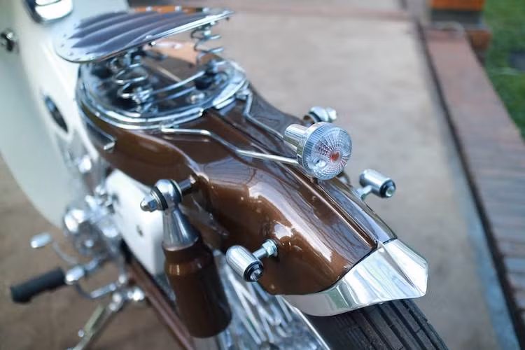 Một tấm ốp trên bình xăng đã được Jezel thiết kế để tạo thành điểm bắt chiếc đèn hậu mini ở phía sau cho chiếc xe, trong khi cặp đèn xi-nhan LED cũng đã được xưởng độ này chế cho bộ vỏ nhôm đẹp mắt và bắt vào vị trí đèn nguyên bản của Super Cub.