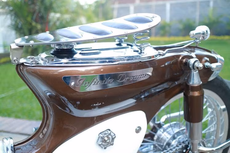 Để tạo điểm nhấn cho chiếc xe, một số chi tiết bằng thép không rỉ CNC đã được ốp trên thân xe, bao gồm khu vực yếm xung quanh động cơ hay cặp logo hai bên bình xăng với tên bản độ "Infinite Dreams" được cắt bằng font chữ mềm mại, tinh tế.