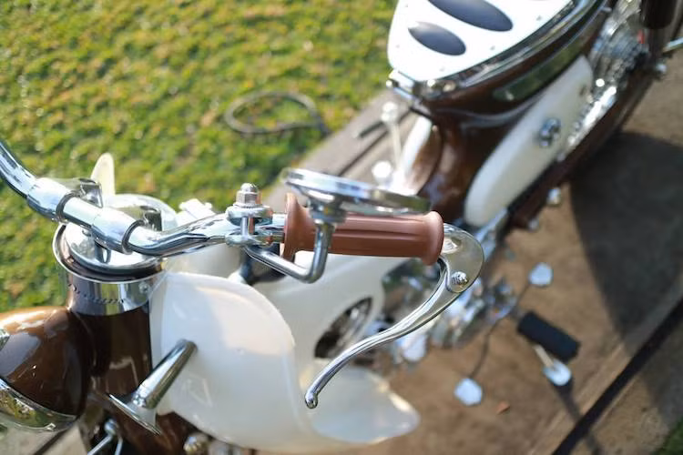 Theo đúng phong cách Street Cub, phần đầu nguyên bản của Super Cub đã được loại bỏ và thay bằng ghi-đông trần. Toàn bộ cụm "sọ khỉ" cùng tay lái và gù ghi-đông cũng được mạ chrome bóng bẩy, trong khi hai bên là cặp bao tay vỏ dưa cùng tay phanh gắn gù đậm chất cổ điển.