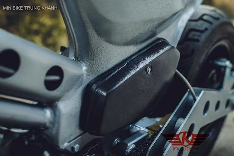 Để có thể tăng độ chịu lực cho khung xe nguyên bản, một gióng ngang bằng thép chịu lực đục lỗ to bản đã được hàn thêm vào bộ khung của chiếc Cub. Toàn bộ thân xe đã được sơn với hiệu ứng sần độc đáo và gam màu bạc sáng, riêng cặp nắp che 2 bên thân có màu đen tạo điểm nhấn.