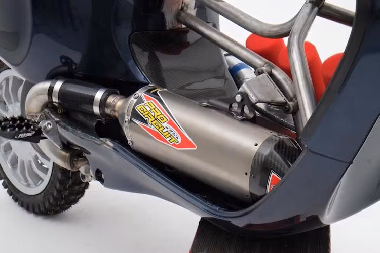 Khối động cơ nguyên bản của Vespa Sprint có kết cấu giữ nguyên. Tuy nhiên ở khu vực sàn xe, Supa Custom đã đặt cây pô Pro Circuit và hộp gió bằng nhôm kèm 3 lọc gió độ "hàng thửa". Do vị trí sàn để chân đã bị chiếm bởi những chi tiết này nên bộ gác chân gai kiểu "cào cào" đã được lắp thêm vào hai bên thân xe.