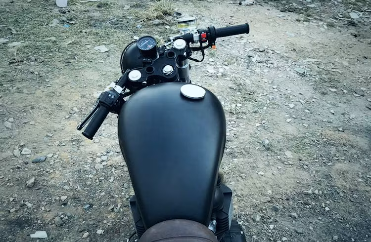 Thay vì gù ghi-đông cùng tay lái cao nguyên bản của Bonneville, chiếc xe đã được thay cặp tay lái clip-on thể thao hơn theo đúng phong cách cafe racer. Ở phía trên chảng ba, cụm đồng hồ nguyên bản của xe cũng được "rút gọn" lại chỉ bằng một đồng hồ điện tử đa năng duy nhất.