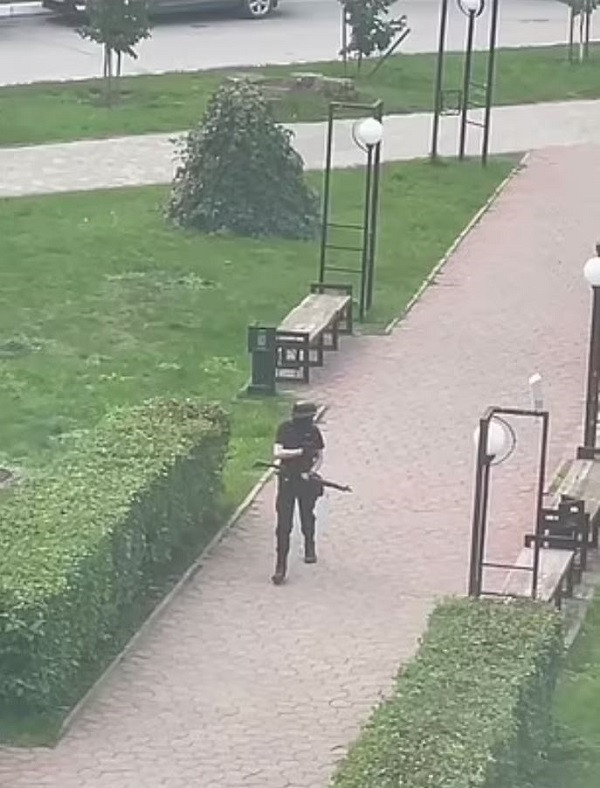 Trong đoạn clip được chia sẻ trên mạng xã hội, tay súng đơn độc mặc đồ màu đen, đầu đội mũ bảo hộ, cầm súng di chuyển trên sân trường