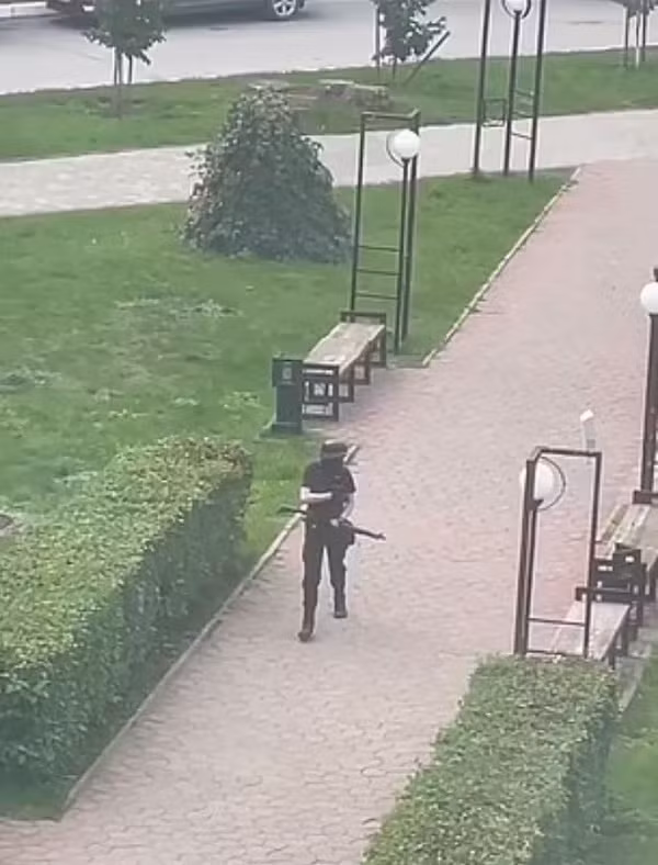 Trong đoạn clip được chia sẻ trên mạng xã hội, tay súng đơn độc mặc đồ màu đen, đầu đội mũ bảo hộ, cầm súng di chuyển trên sân trường