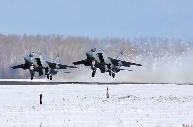 Biên đội tiêm kích đánh chặn MiG-31 của Không quân Nga cất cánh, động cơ phản lực khiến tuyết bắn tung tóe đằng sau.