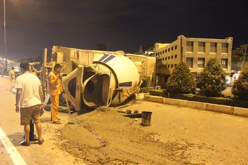 Xe trộn bê tông bị lật nhào giữa đường
