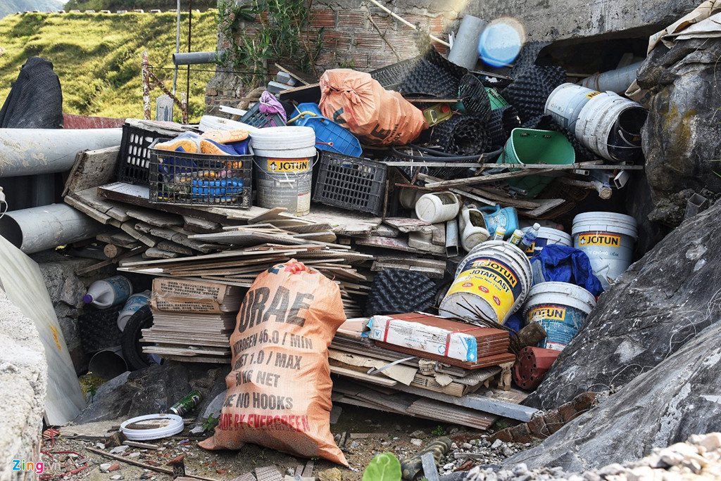 Rác thải của quá trình xây dựng công trình vẫn dồn đống ở tầng dưới cùng, một số vật liệu xây dựng vương vãi xuống triền núi.