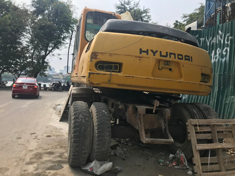 Một chiếc máy xúc không hoạt động nằm phía ngoài dự án.