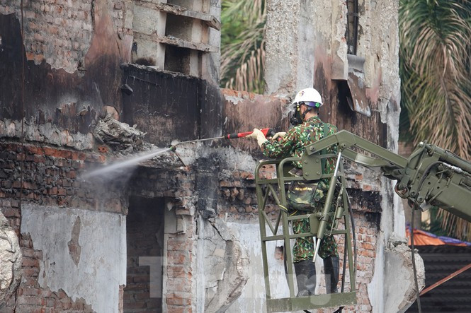 Dùng xe thang chứa dung dịch tiêu tẩy “tắm rửa” nhà xưởng Rạng Đông