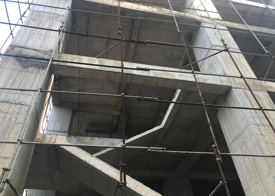 Hệ thống giàn giáo sắt bên trong công trường để căng lưới, đảm bảo an toàn trong quá trình thi công, tránh cho vật liệu xây dựng rơi ra phía ngoài hiện nay đã hoen rỉ.